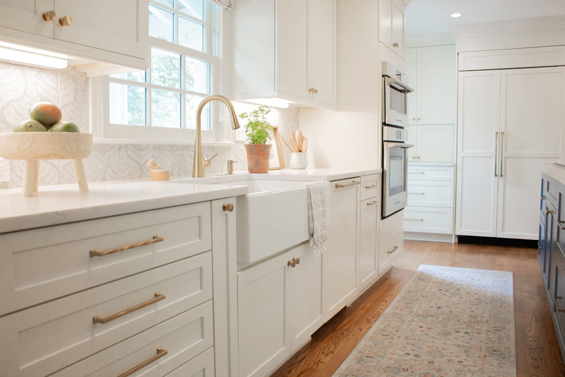 Kitchen Remodel in Brentwood Tennessee House with white cabinets, quartz countertop, gold hardware, apron sink