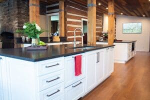 Brentwood kitchen renovation in log home with white cabinets, black countertops
