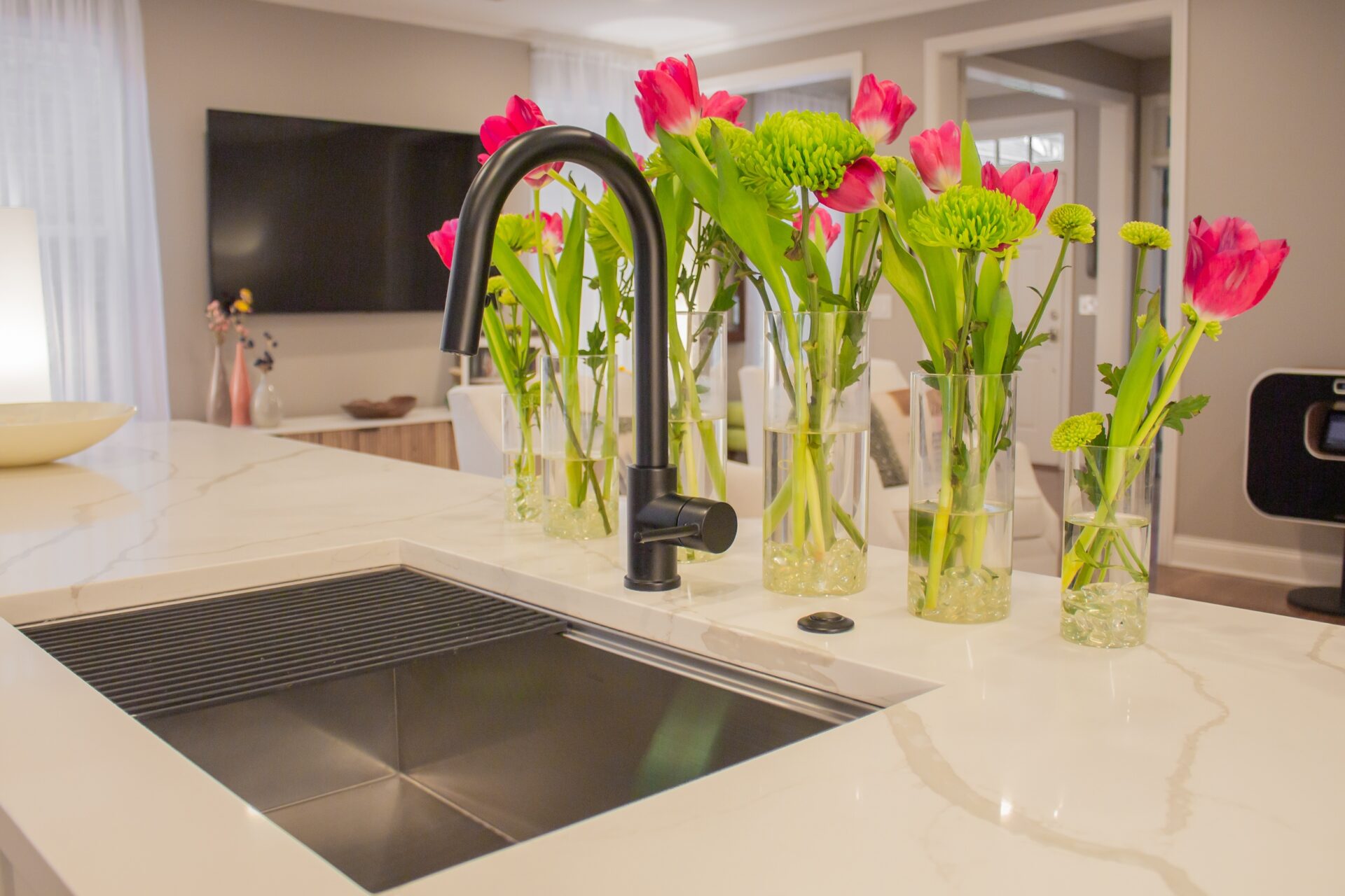 kitchen sink with quartz countertop black faucet and pink tulips behind faucet. from a kitchen remodel frankin tn